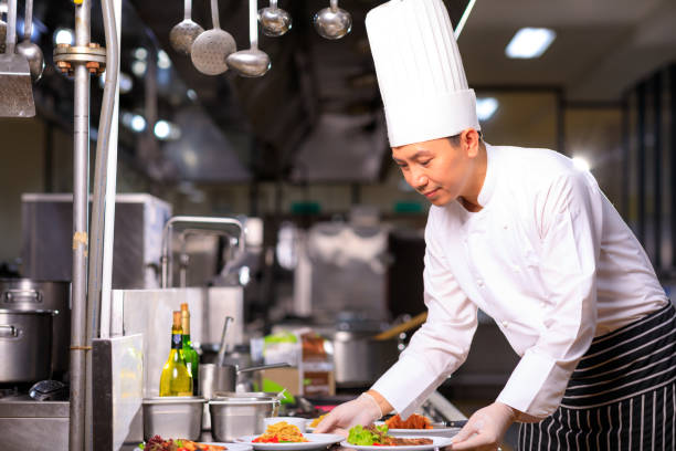 istock Asian Male chef presenting the dish in the kitchen. Selective focus. 1334973260