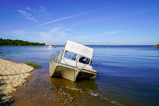 small pleasure motor boat wrecked and stranded on the beach