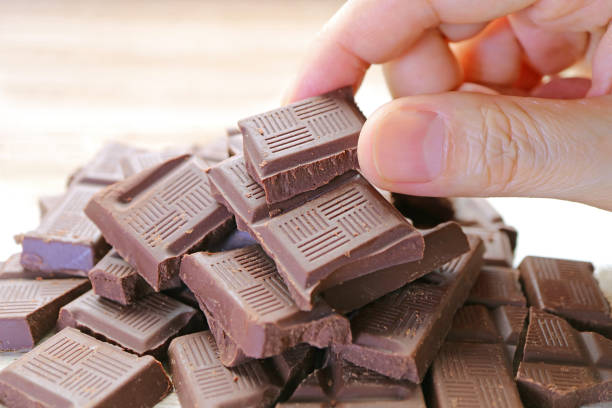 istock Closeup man's hand picking a chocolate chunk from the pile 1334976503