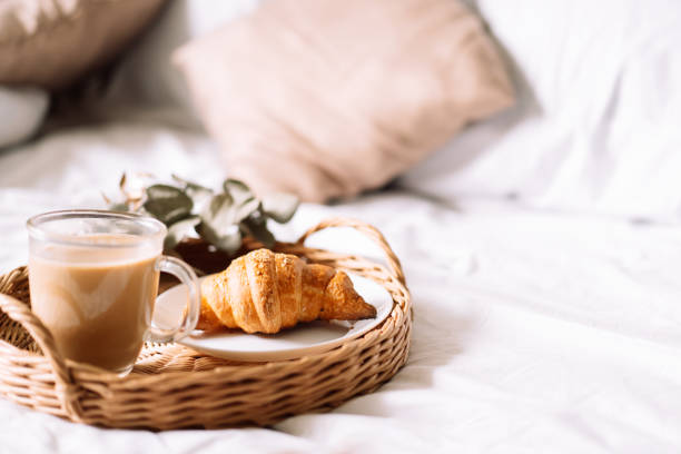istock Breakfast in bed with croissant and coffee on tray 1334976547