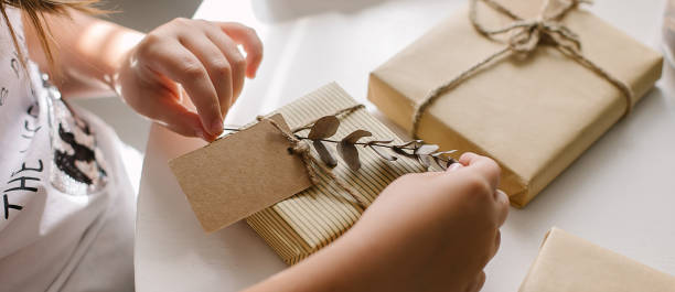 istock Female hands packing gift decor with eucalyptus and note cart for text. Zero waste Christmas 1334977464