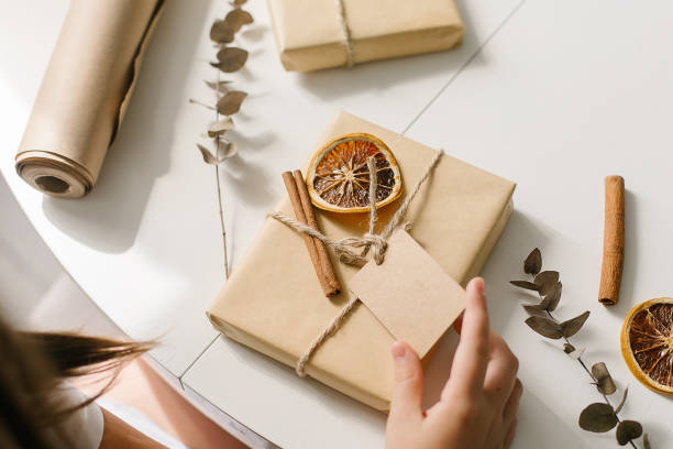 istock Female hands packing gift decor with dry orange, cinnamon sticks, eucalyptus. Zero waste Christmas 1334977470