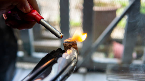 istock Hand using a gas lighter starter to ignite camping charcoal cock fire starter. 1334978037