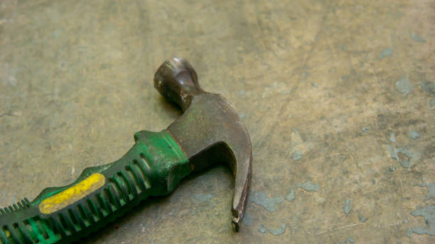 istock An old mini small hammer with green rubber handle on the floor. 1334978306