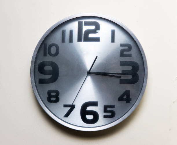 horloge murale en argent accrochée au mur blanc. - clock wall clock face clock hand photos et images de collection