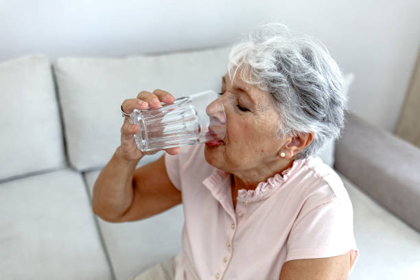 istock Beautiful old woman drinking water. 1334978982