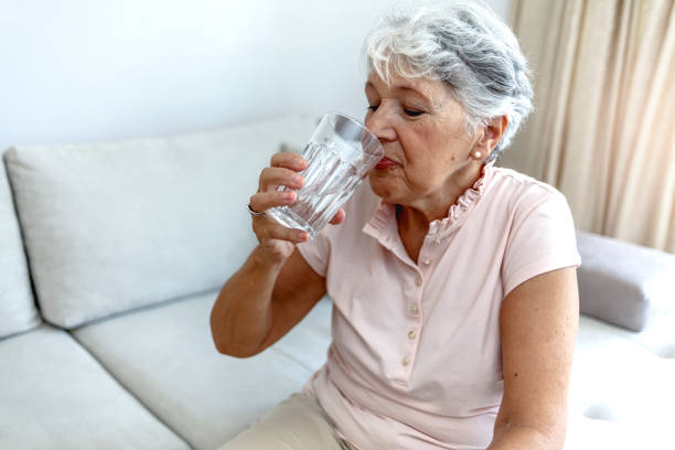istock Beautiful old woman drinking water. 1334979015