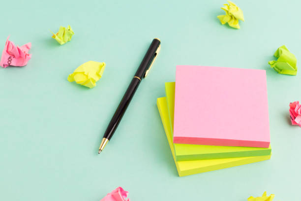 istock Empty colorful sticky note paper with pen and crumpled paper on turquoise background. 1334979171