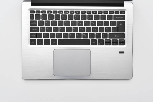 istock Keyboard of a modern compact laptop with English layout and touchpad. Minimal workspace with portable computer laptop keyboard for online working and writing text. 1334979438