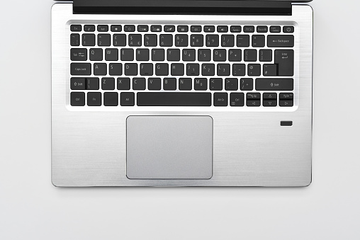 Keyboard of a modern compact laptop with English layout and touchpad. Minimal workspace with portable computer laptop keyboard for online working and writing text.