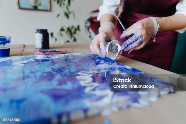 Artist Mixing Acryl Paints On The Picture Working In Fluid Art Technique Stock Photo - Download Image Now