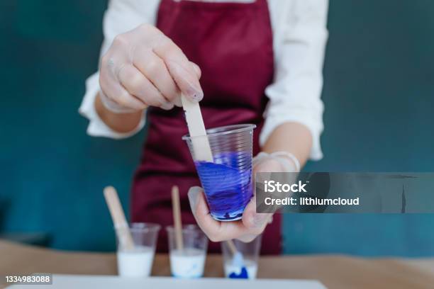 Female Artist Pouring Acrylic Medium For Painting Picture In Fluid Pouring  Technique Stock Photo - Download Image Now - iStock