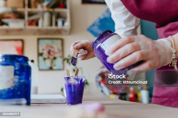 Female Artist Pouring Acrylic Medium For Painting Picture In Fluid Pouring  Technique Stock Photo - Download Image Now - iStock