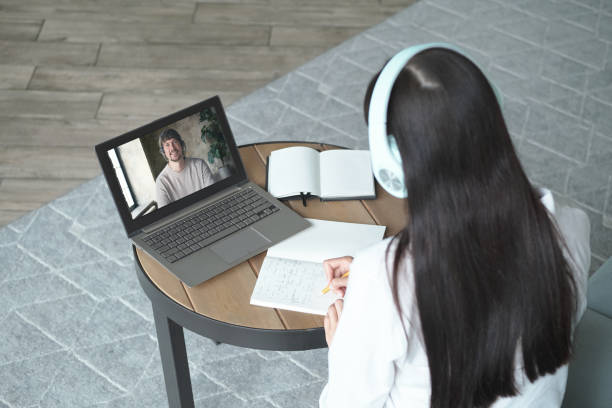 istock Young woman studying online using laptop and video call with teacher and learning 1334984086