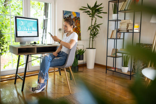 istock Young woman checking her social media using smartphone while taking a break from work at home 1334984205