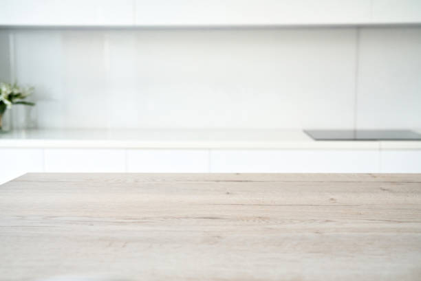 istock Kitchen table top and blur background of glossy kitchen interior. Minimal or scandy style. 1334984237