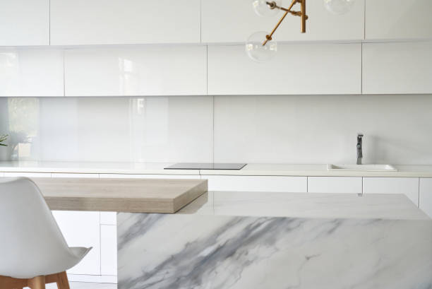 istock Kitchen table top and blur background of glossy kitchen interior. Minimal or scandy style. 1334984316