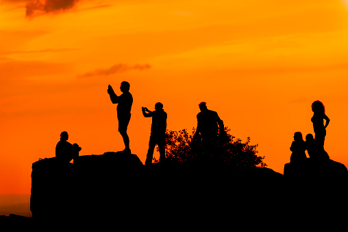 Tourists Shooting selfies on a rock in the evening light