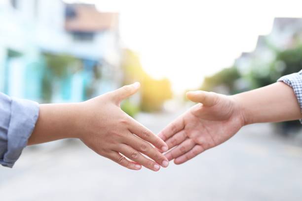istock Men in T-shirts are shaking hands to greet each other. 1334984823