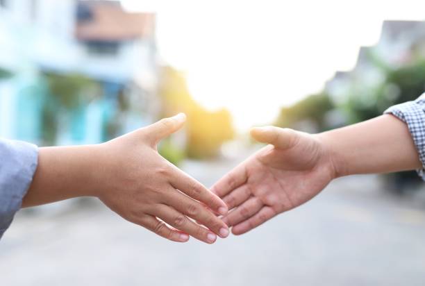 istock Men in T-shirts are shaking hands to greet each other. 1334984906