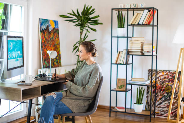 istock Young woman drawing on graphics tablet while working from home 1334985178