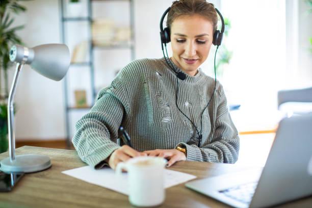istock Young woman sitting at desk and working from home using laptop 1334986838