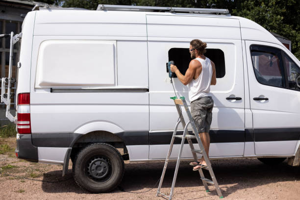 istock Man cut a hole for a window into the side door of a van 1334987931