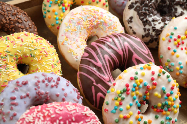 istock Yummy glazed donuts with sprinkles, closeup view 1334988832