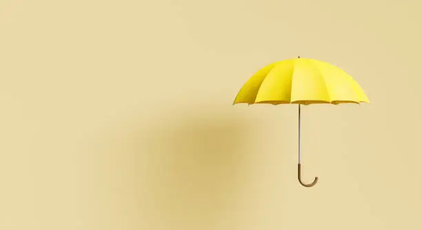 Photo of yellow umbrella on beige background with shadow