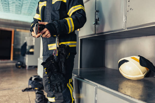 istock One male firefighter dressed in uniform with protective helmet at fire station. Cropped image 1334989846