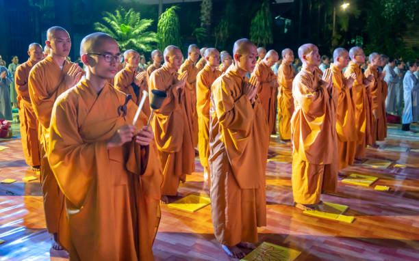 Ho Chi Minh City, Vietnam - December 12th, 2019: Monks are chanting prayers for peace during annual Amitabha Buddha ceremony held in evening at an ancient temple in Ho Chi Minh City, Vietnam