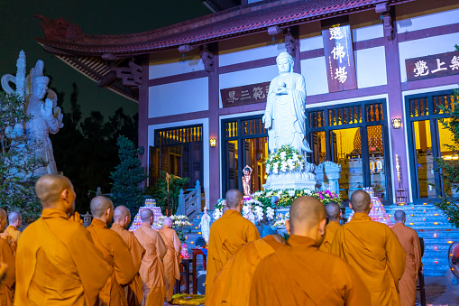 Ho Chi Minh City, Vietnam - December 12th, 2019: Monks are chanting prayers for peace during annual Amitabha Buddha ceremony held in evening at an ancient temple in Ho Chi Minh City, Vietnam