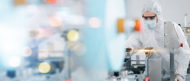 istock Scientists wearing protective clothing Inspect mask making machines in a laboratory at an industrial plant. Anti-virus production warehouse. concept of safety and prevention coronavirus covid-19. 1334991135
