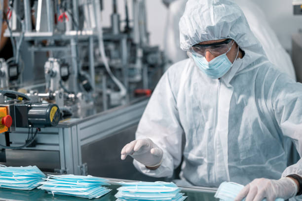istock Scientists wearing uniform protection. Check the manufacturing process of face masks. In a laboratory at industry plants. The concept for security and protection coronavirus covid-19. 1334991268