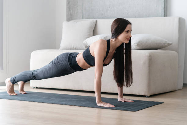 istock Woman standing in plank position at home 1334993561