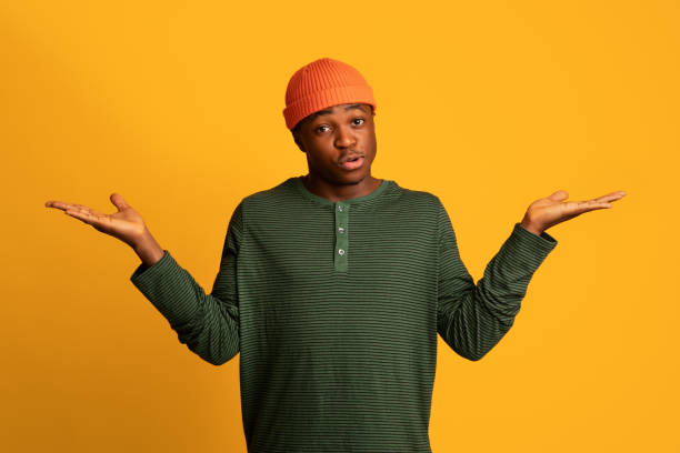 istock Who Knows. Doubtful Young Black Man Shrugging Shoulders And Spreading Arms 1334994478