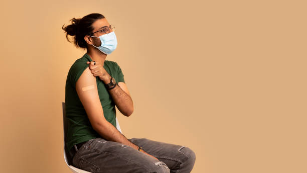 istock Indian man in face mask got vaccinated, showing shoulder 1334994536