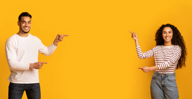 istock Best Offer. Cheerful Middle-Eastern Couple Pointing At Copy Space In The Middle 1334994611