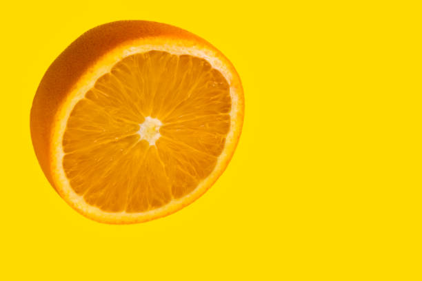 istock Orange cut in half isolated on yellow 1334996589