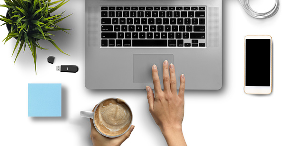 hand over a laptop with coffee and office equipment on white background