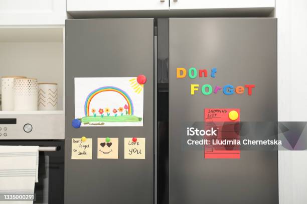 Modern Refrigerator With Childs Drawing Notes And Magnets In Kitchen Stock Photo - Download Image Now