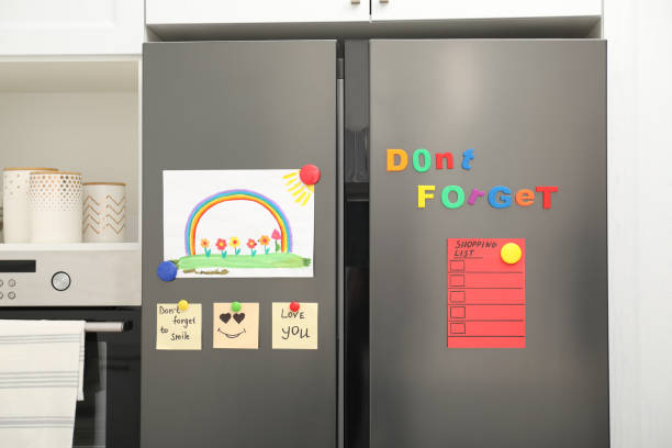 modern refrigerator with child's drawing, notes and magnets in kitchen - magnetic storage imagens e fotografias de stock