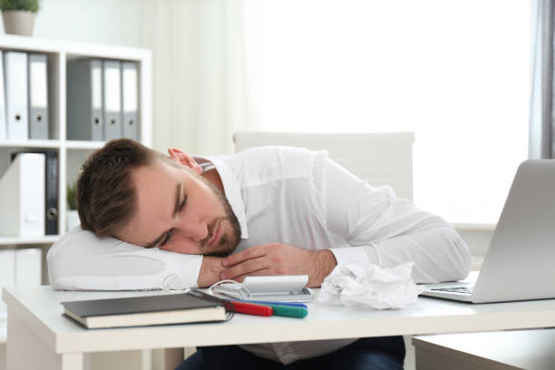 istock Lazy young man wasting time at messy table in office 1335000497