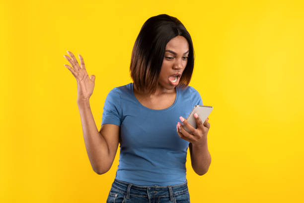 istock Angry Black Lady Holding Phone And Shouting On Yellow Background 1335002467