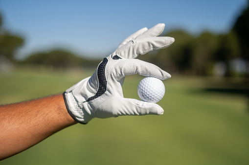 Golf player man holding golf ball.