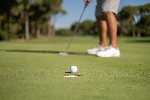 Golf player putting on green.