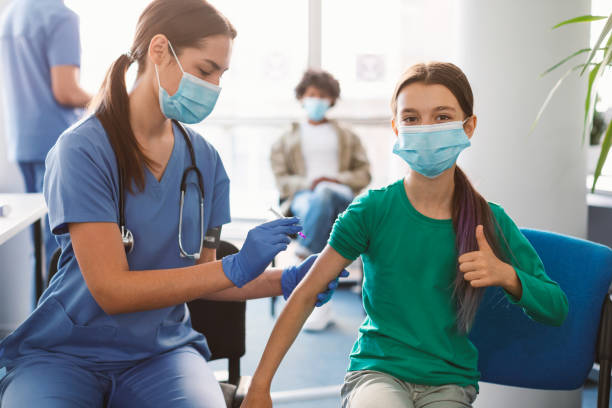 Girl Getting Vaccinated Against Covid-19, Showing Thumbs Up