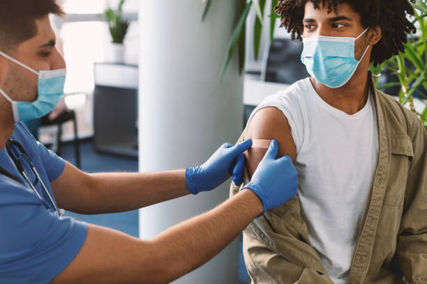 istock Black Guy Getting Vaccinated Against Covid-19, Doctor Applying Plaster 1335002867