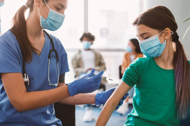 alumno que recibe la inyección de la vacuna contra el coronavirus sentado con el médico en interiores - vacunación fotografías e imágenes de stock