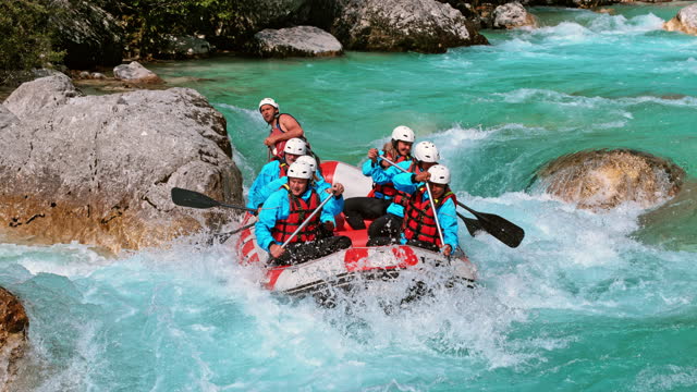 SLO MO LD Team of white water rafters rowing across the rapids